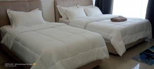 话毛生RJ STUDIO APARTMENT 2- Hotel Mutiara的客房内的两张床、白色的毯子和枕头