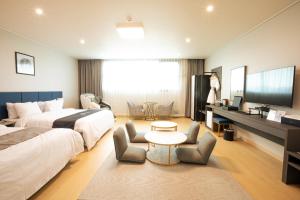 KangjinGangjin K-Stay Tourist Hotel的酒店客房配有两张床和一张书桌