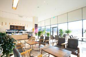 KangjinGangjin K-Stay Tourist Hotel的一间设有桌椅和窗户的自助餐厅