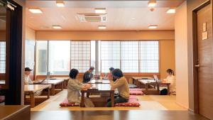 东京COGO Ryogoku的一群坐在餐厅桌子上的人