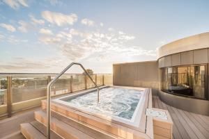 悉尼Oaks Sydney Hyde Park Suites的大楼阳台上的热水浴池