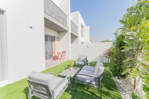 迪拜Cosy Luxury villa Tilal Alghaf的一个带椅子和桌子的庭院