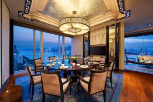 杭州杭州绿城尊蓝钱江豪华精选酒店的一间带桌椅和大窗户的用餐室
