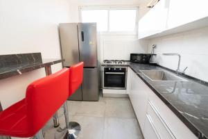 巴特亚姆Beautiful apartment near Tel Aviv的厨房配有不锈钢冰箱和红色椅子