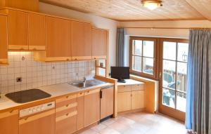 拉古多加尼文克勒霍夫酒店的厨房配有木制橱柜、水槽和窗户。