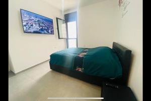 荷兹利亚New- Luxury Glil Yam For Family 4 Rooms Parking的一间位于客房内的带绿床的卧室