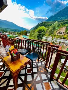 马拉里Himalayan Riverside Resort, Manali的美景阳台配有桌椅