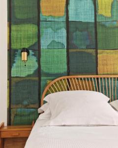 基伯龙Louison Appart & Suite的一张带木制床头板的床和一堵带