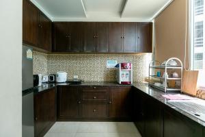 芭堤雅市中心芭堤雅卧房旅社的厨房配有木制橱柜和台面
