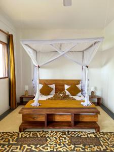 江比阿Kholle Villa的一间卧室配有一张带天蓬的床