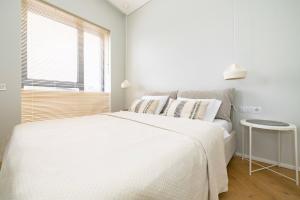 帕兰加Vanagupes Park Apartment, By Cohost的白色的卧室设有一张大床和一个窗户