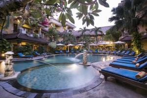 沙努尔帕瑞吉塔度假酒店及水疗中心的游泳池,酒店配有椅子和遮阳伞