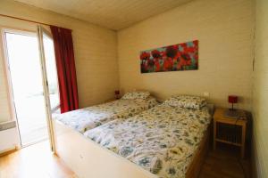 加桑GASMIM29 - Golfe de St-Tropez, chalet climatisé dans domaine arboré的卧室配有一张床,墙上挂有绘画作品