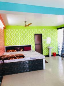 帕格尔布尔Shree Hotels的一间卧室配有一张带绿色墙壁的床
