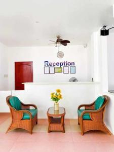 BacongKakisa ll Diving Resort的一间等待室,配有两把椅子和一张带鲜花的桌子