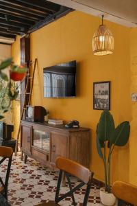 胡志明市Ben Thanh_Unique Vietnamese cultural house_Bathtub的一间起居室,在黄色的墙上配有电视