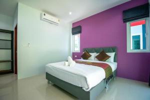 Ban Bang Puบ้านพักชายคลอง @บางปู สามร้อยยอด的一间卧室配有一张紫色墙壁的床