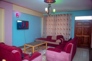 纳纽基Balozi Luxury Homes的客厅配有红色椅子和桌子