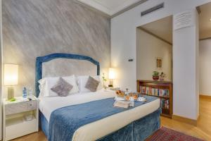 佛罗伦萨里沃利精品酒店的一间卧室配有一张大床和蓝色床头板