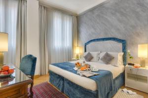 佛罗伦萨里沃利精品酒店的一间酒店客房,配有一张床铺,上面装有水果盘