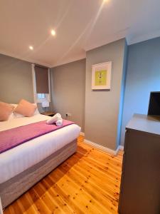 戈尔韦Stylish 3 Bedroom Galway House的一间卧室配有一张床和一台平面电视