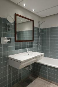奥胡斯赫尔南玛瑟丽思酒店的浴室配有盥洗盆、镜子和浴缸
