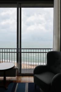 奥胡斯赫尔南玛瑟丽思酒店的一间带椅子的客厅,享有海滩美景