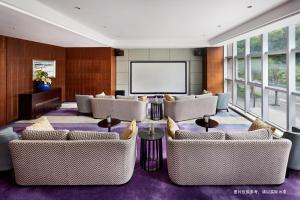 深圳第一太平戴维斯赛嘉服务式公寓大新深圳港湾的大型客房设有沙发和投影屏幕