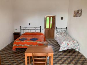 斯特龙博利Case La Pergola的一间卧室设有两张床和一张木桌