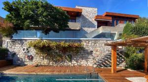 卡迪马里奥La Villa with heated pool and amaizing view的一座带游泳池和石墙的房子