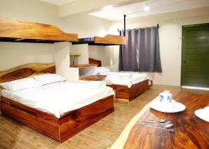 san juan la unionLone Star Inn的铺有木地板的客房内的两张床