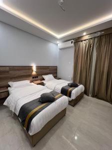 AR Rummanahبارك بلس للشقق المخدومة的一间卧室设有两张床和窗户。