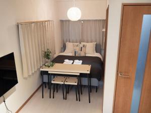 东京Lido North Shinagawa的一间小卧室,配有一张床和一张桌子