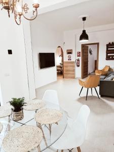 马德里Violeta Suite的客厅配有玻璃桌和白色椅子