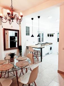 马德里Violeta Suite的厨房以及带玻璃桌和椅子的用餐室