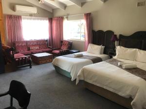 库鲁曼Janke Guest House的酒店客房,设有两张床和一张沙发