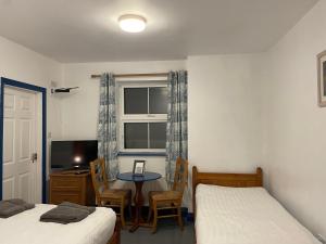丁格尔Coastguard Lodge Hostel at Tigh TP的一间卧室设有两张床、一张桌子和一个窗口