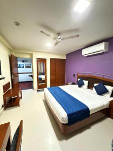 新德里Hotel Divine Admire Opp Gurudwara Sahib in Taimoor Nagar-Friends Colony的一间卧室设有一张大床和紫色的墙壁
