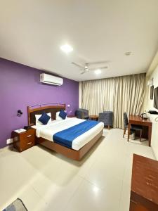 新德里Hotel Divine Admire Opp Gurudwara Sahib in Taimoor Nagar-Friends Colony的一间卧室配有一张床和紫色的墙壁