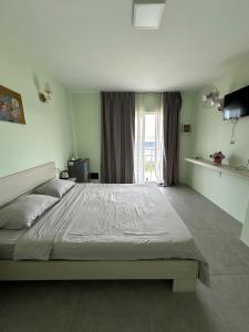 西哈努克Ginger Sihanoukville的一间卧室设有一张大床和一个窗户。