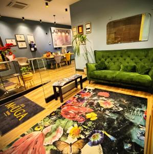 埃洛里奥M&UGA Hotela的客厅配有绿色沙发和地毯。