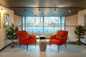 伯明翰Aparthotel Birmingham的带大窗户的客房内的两把橙色椅子