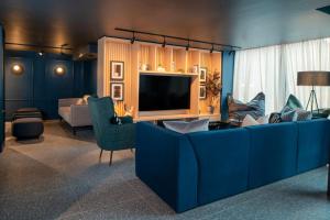 伯明翰Aparthotel Birmingham的客厅配有蓝色的沙发和电视