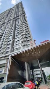 吉隆坡M Vertica Premier Suites by BlueBanana的一座高大的建筑,前面有汽车停放