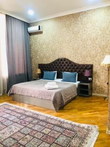 巴库Pilot hotel Baku center的一间卧室配有一张带蓝色枕头的床和地毯。