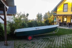 NeuendorfFerienhaus am kleinen Hafen的停在房子旁边的院子中的一艘绿色船只