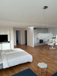 汉堡Außenalster Penthouse Charakter的白色卧室配有一张床和一个吊灯