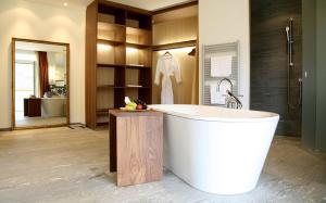 达沃斯Waldhotel & SPA Davos - for body & soul的带浴缸和盥洗盆的大浴室