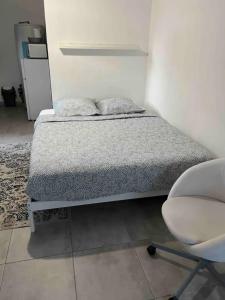 RoaixGuest house en Provence的一张带两个枕头的床和一把椅子