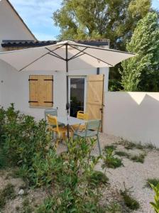 RoaixGuest house en Provence的房屋前的桌椅和遮阳伞